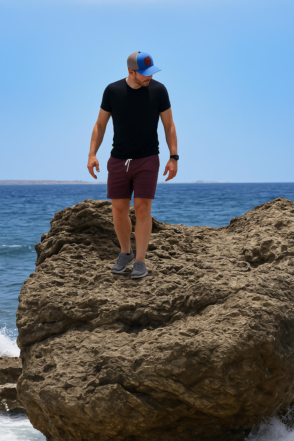 Ryan standing on coastal rocks above the ocean